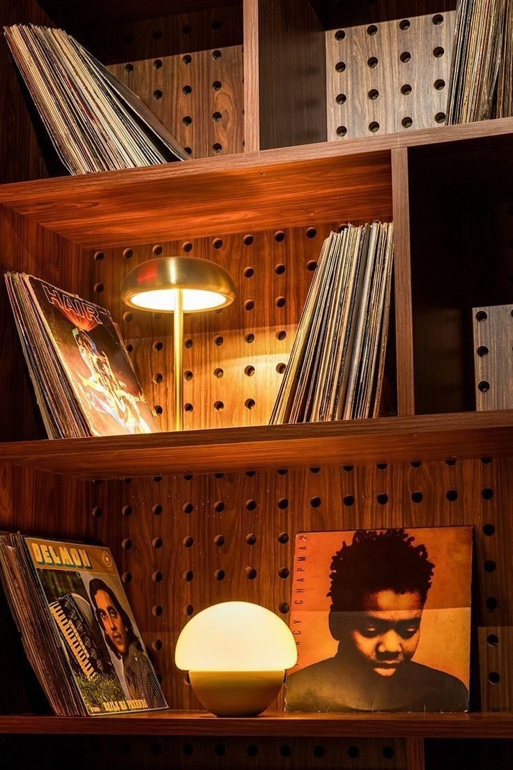 Walnut record shelves with brass and glass lamps, lit warm.
